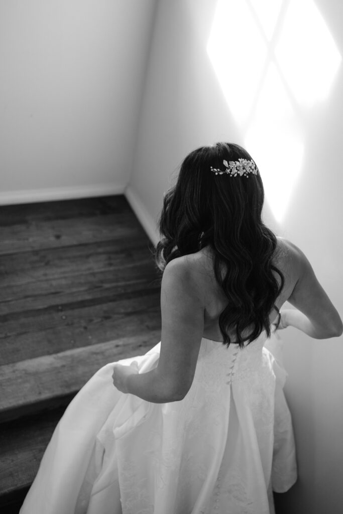 bride walking down staircase while holding her dress up