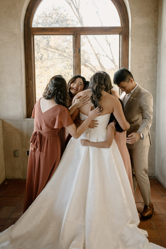 first look with bridesmaids, bride hugging bridesmaids after their first look