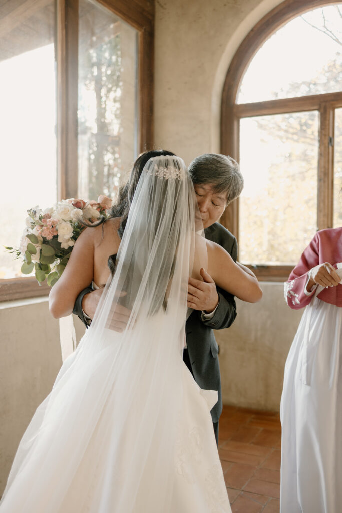 father hugging daughter before wedding ceremony