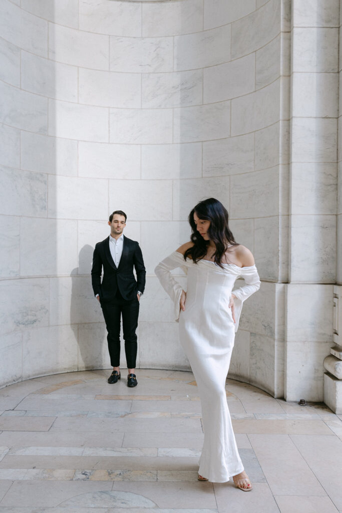 woman standing in front of man while posing for engagement photos